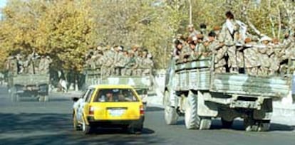 Camiones repletos de guerrilleros de la Alianza del Norte avanzan por la principal avenida de Kabul.