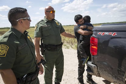 Un migrante abraza a su hijo al momento de ser detenido por la Patrulla de la Frontera en Roma, Texas