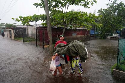 'Idalia', que el lunes ya dejó graves daños en Cuba y obligó a decenas de miles de personas a abandonar sus hogares. En la imagen, personas caminan por una calle inundada en Guanimar, Cuba.