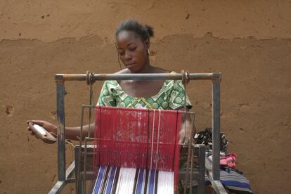 Véronique Douamba, de 37 años, teje los hilos de algodón a la manera tradicional. Al igual que Rosalie, también consiguió el material gracias a Afedi.