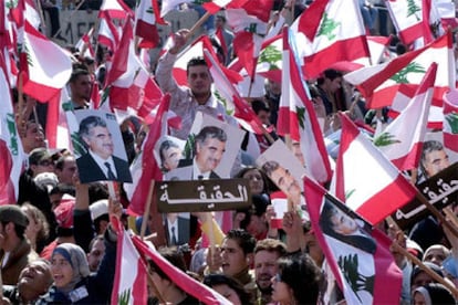 Manifestantes libaneses portan banderas del país y retratos del asesinado Rafik Hariri.