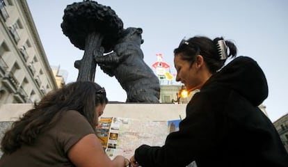 Dos turistas consultan un mapa de Madrid en la Puerta del Sol.