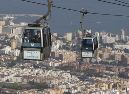 Dos turistas saludan desde una de las cabinas del teleférico de Benalmádena, el pasado lunes.