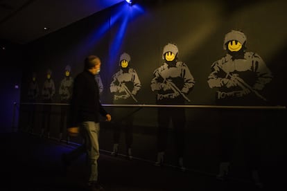 Una de las salas de la exposición recrea una suerte de pasillo policial en la oscuridad, solo iluminado por luces intermitentes y el sonido de la gente en la calle.