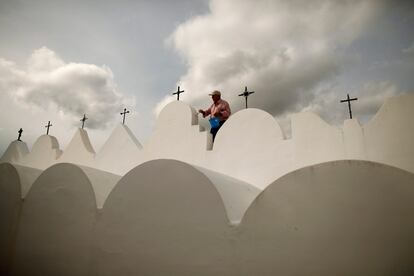 Un hombre pinta unos nichos en el cementerio de Casabermeja, en Málaga, pocos días antes de la celebración del Día de los Difuntos.