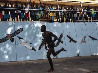 Uno de los inmigrantes alcanza corriendo el CETI y es aclamado por otros llegados anteriormente.