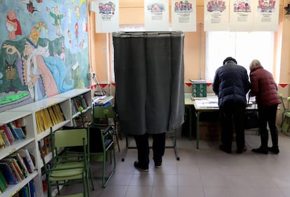 Varios electores escogen su papeleta en el colegio público La Navata, en Galapagar.