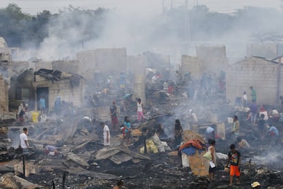 Vecinos de un suburbio de Navotas buscan entre los restos de sus casas calcinadas en Manila (Filipinas), el 10 de enero de 2017. El fuego arrasó más de 600 chabolas y dejó a más de 1.500 familias sin hogar.