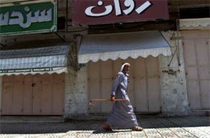 Un palestino pasa por delante de un negocio cerrado en Gaza.