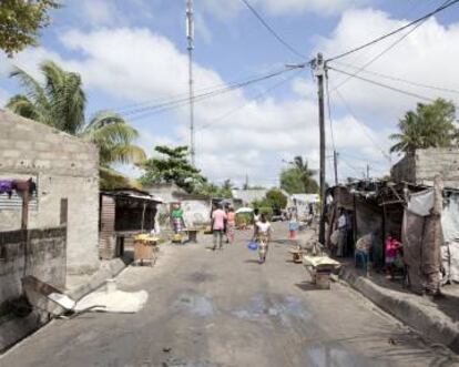 Arriba, unos niños juegan en Macurungo, un barrio de las afueras, al este de la ciudad de Beira, en Mozambique. Abajo, una vista del barrio, que es de los más pobres de la ciudad.