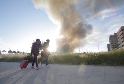 Una pareja durante el desalojo de los vecinos de la urbanización El Quiñon de Seseña (Toledo) para evitar cualquier tipo de riesgo a la población por la nube de humo producida a raíz del incendio del vertedero de neumáticos, el 13 de mayo.