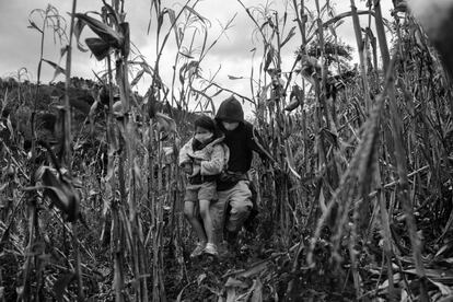 Un hombre corre con su hija en brazos cerca de Vado Hondo, en Guatemala.