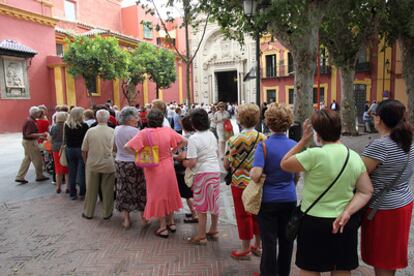 Una larga cola cruza la plaza sevillana de San Lorenzo para ver al restaurado Cristo del Gran Poder.