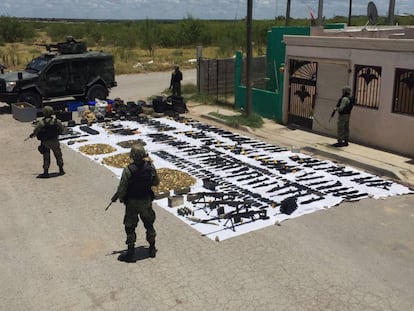 Tropas del Ejército, junto a un arsenal de armas decomisado en julio.