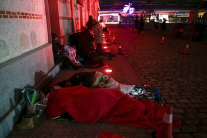 Varias personas descansan en el suelo en el espacio cultural Matadero. 