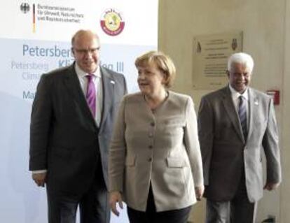 La canciller alemana, Angela Merkel (c), junto al ministro alemán de Medio Ambiente, Peter Almaier (i) y el viceprimer ministro catarí Abdullah bin Hamad Al-Attiyah (d).