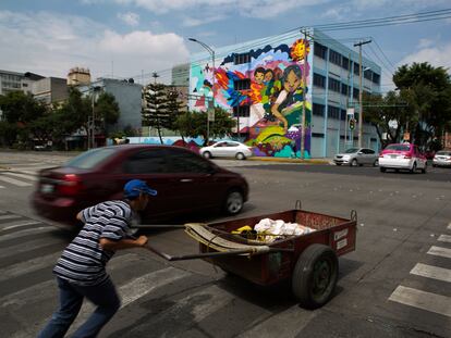 Un hombre intenta cruzar una avenida con una carretilla, en Ciudad de México, en una imagen de archivo.