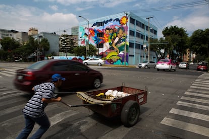 Un hombre intenta cruzar una avenida con una carretilla, en Ciudad de México, en una imagen de archivo.