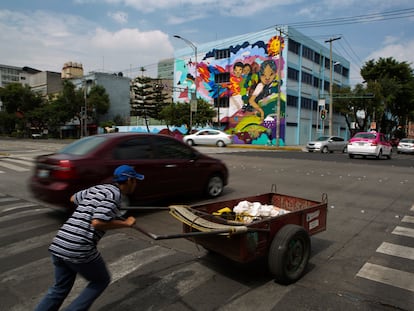 Un hombre intenta cruzar una avenida con una carretilla, en Ciudad de México, en una imagen de archivo.