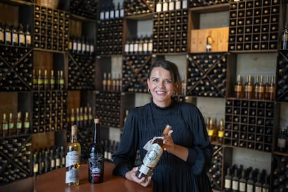 Silvia Flores con tres embotellados de vinos que han sido transportados en el Buque Escuela Juan Sebastián Elcano.