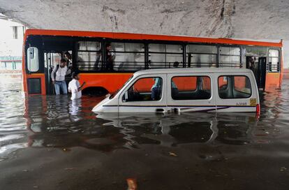 Vehiculos sumergidos en una carretera inundada bajo el puente Minto, durante la fuerte lluvia monzónica en Nueva Delhi (India).