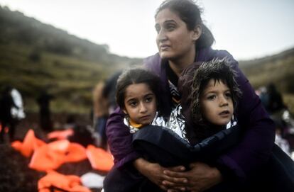 Una madre abraza a sus hijos después de desembarcar en la isla griega de Lesbos tras cruzar el mar Egeo procedentes de Turquía, el 19 de noviembre de 2015.