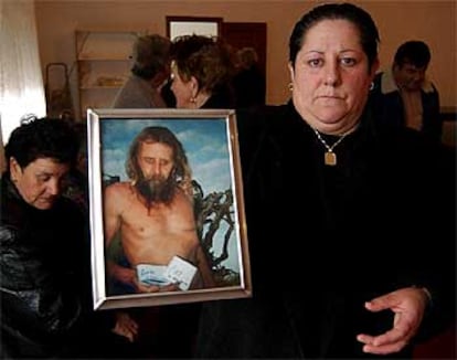 Mujeres de Camelle muestran un retrato de Man en el velatorio del fallecido.