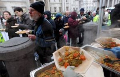 Personas reciben gratuitamente un plato con comida en la plaza Trafalgar de Londres, (Inglaterra). EFE/Archivo