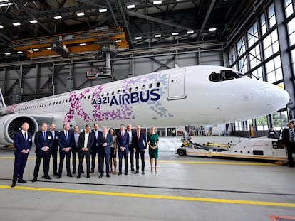 El canciller alemán, Olaf Scholz, y el CEO de Lufthansa, Carsten Spohr (centro), posan junto a un aparato de Airbus A321.