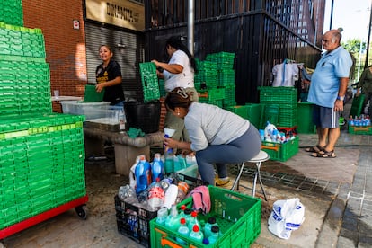 Miembros de la asociación limpian, mientras otra reenvasa el suavizante donado para que alcance para todos.