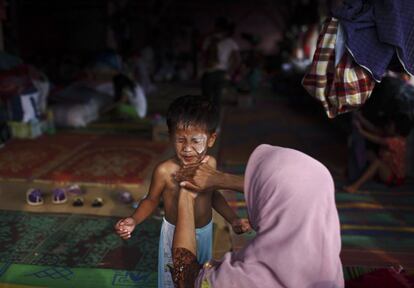 Una mujer, que fue evacuada de su hogar debido a la erupción del Monte Sinabung, baña a su hijo en un refugio temporal en Berastagi, Sumatra (Indonesia), 5 de febrero 2014.