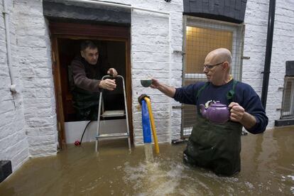 La alerta sigue activada en las zonas más afectadas de los condados de Lancashire y Yorkshire, en el área del Gran Manchester y en Cumbria ante la previsión de nuevas precipitaciones intensas a mediados de esta semana. En la imagen, unos vecinos afectados por las inundaciones en York.