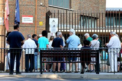 Varias personas hacen cola para entrar a votar en el colegio Escuelas Aguirre, este domingo en Madrid.
