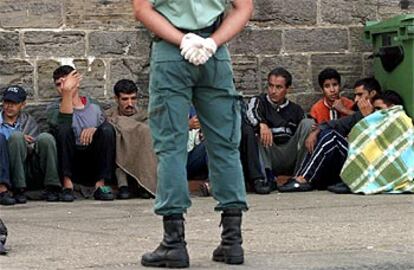 Un guardia civil vigila a los inmigrantes en la Isla de las Palomas, a la espera de su repatriación.