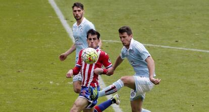 El jugador del Sporting Carlos Castro, y Planas y Radoja, del Celta de Vigo, durante el partido correspondiente a la jornada 32 de la Liga de Primera Divisi&oacute;n