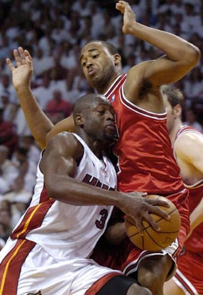 Dwayne Wade de los Heat de Miami penetra a canasta ante la oposición de Othella Harrington (dcha.) de los Bulls de Chicago.