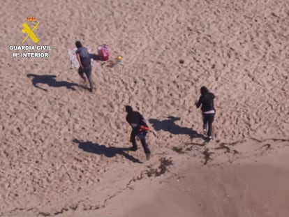 Momento en el que los tres presuntos ocupantes de la narcolancha emprenden la huida tras dejar la embarcación en la playa de Cala Gran, en el municipio de Santanyí.