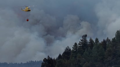 Un helicóptero sobrevolaba el jueves una columna de humo en el incendio forestal en Villanueva de Viver.
