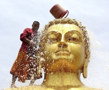 Un monje budista limpia una estatua de Buda de cara a las celebraciones de su cumpleaños en un monasterio de Bhopal (India). El 2.560º aniversario del nacimiento de Buda se celebrará el próximo 21 de mayo en todo el mundo.