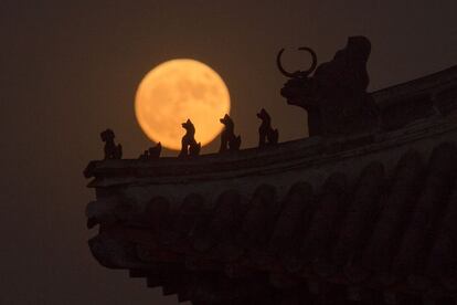 A Superlua sobre esculturas da Cidade Velha de Pequim (China).