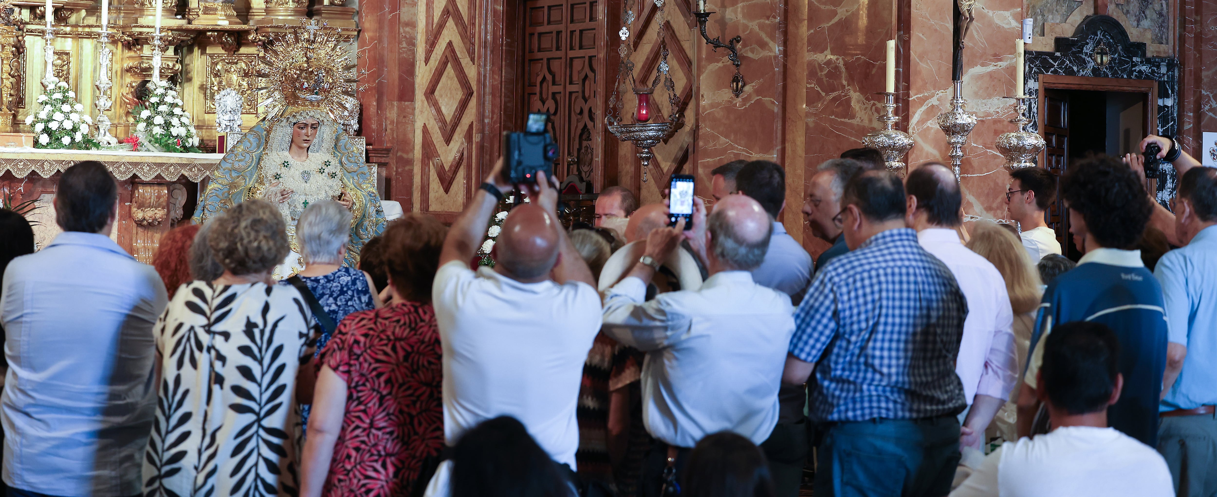 Fieles fotografían la imagen restaurada de la virgen Macarena este lunes.