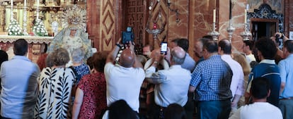 Fieles fotografían la imagen restaurada de la virgen Macarena este lunes.
