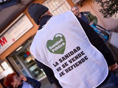 Un hombre en la puerta del centro de salud de Abrantes, en Madrid, donde se ha instalado una mesa de recogida de firmas para solicitar más médicos.