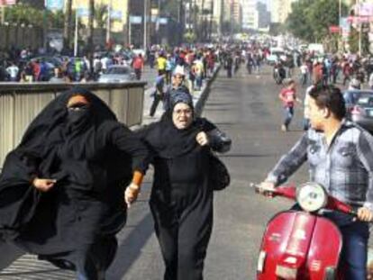Dos mujeres egipcias contrarias al grupo "Los Hermanos Musulmanes", huyen de miembros de ese movimiento, durante unos disturbios entre miembros del grupo "Los Hermanos Musulmanes", ilegal en Egipto, y del movimiento "Bloque Negro", en El Cairo (Egipto). EFE/Archivo