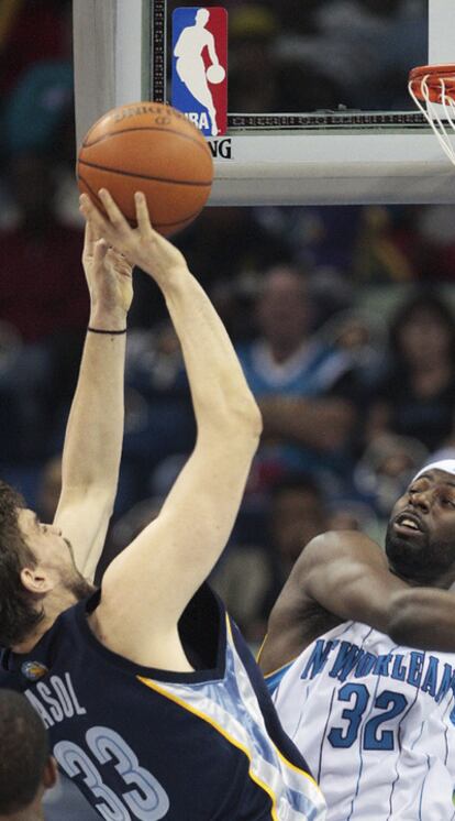 Marc Gasol, de los Grizzlies, trata de lanzar el balón ante Julian Wright, de los Hornets.