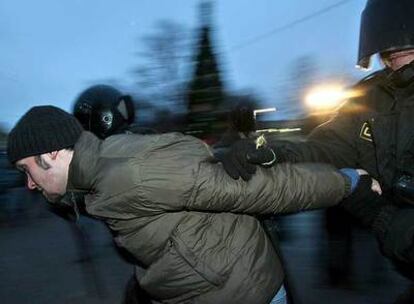 Agentes de policía rusos detienen a un miembro de Oposición Unida durante una manifestación contra los resultados de las elecciones legislativas.