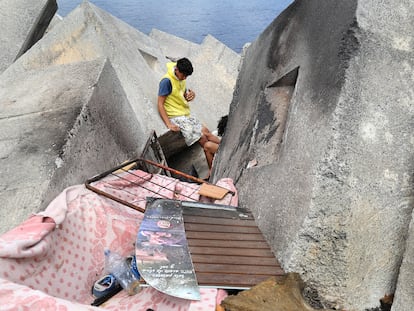 Dos menores se despiertan este julio en una chabola en la escollera de la playa de Ceuta, donde viven desde hace más de dos meses.