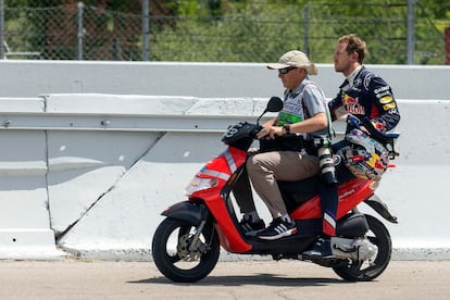 Vettel llevado por un fotógrafo en su scooter