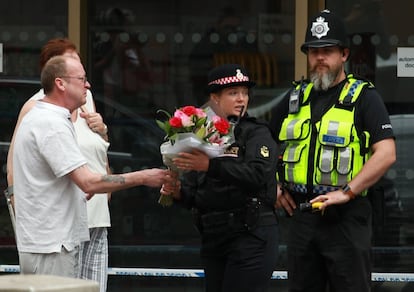 Miembros de la policía recogen flores tras el atentado terrorista del pasado sábado.