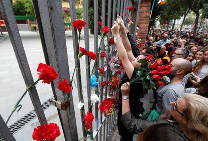 Ciudadanos colocan flores en la puerta del colegio Ramón Lllull donde la Policía Nacional cargó contra los votantes.